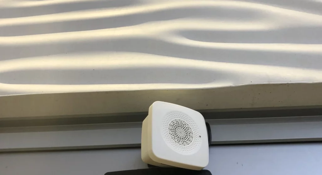 An white audio beacon at an entrance