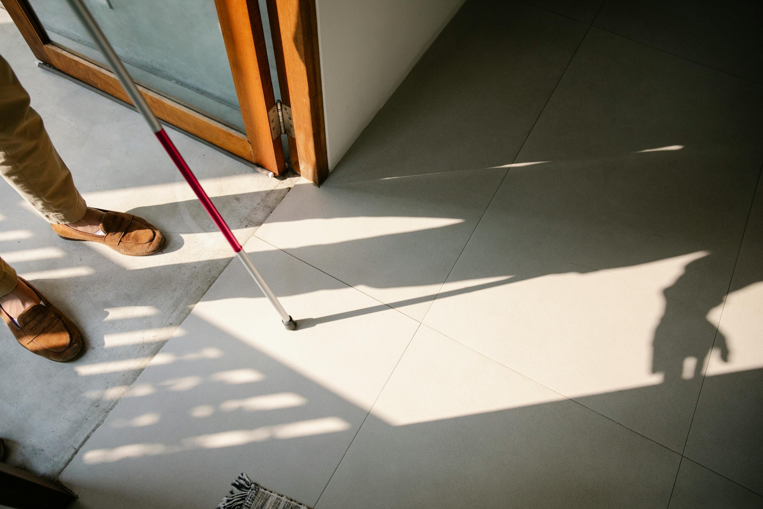 background of a visually impaired man holding a white stick